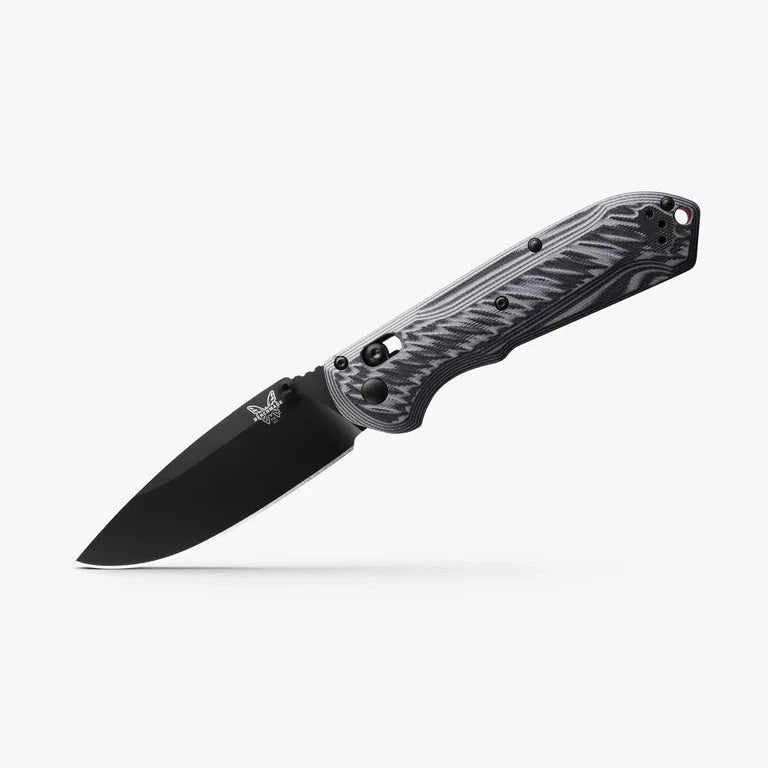 Folding knife with black blade and camouflage handle on a white background