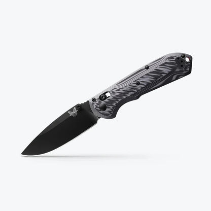 Folding knife with black blade and camouflage handle on a white background