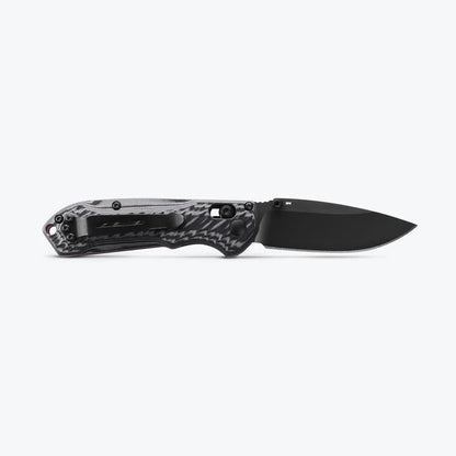 Black folding knife with a carbon fiber handle on a white background