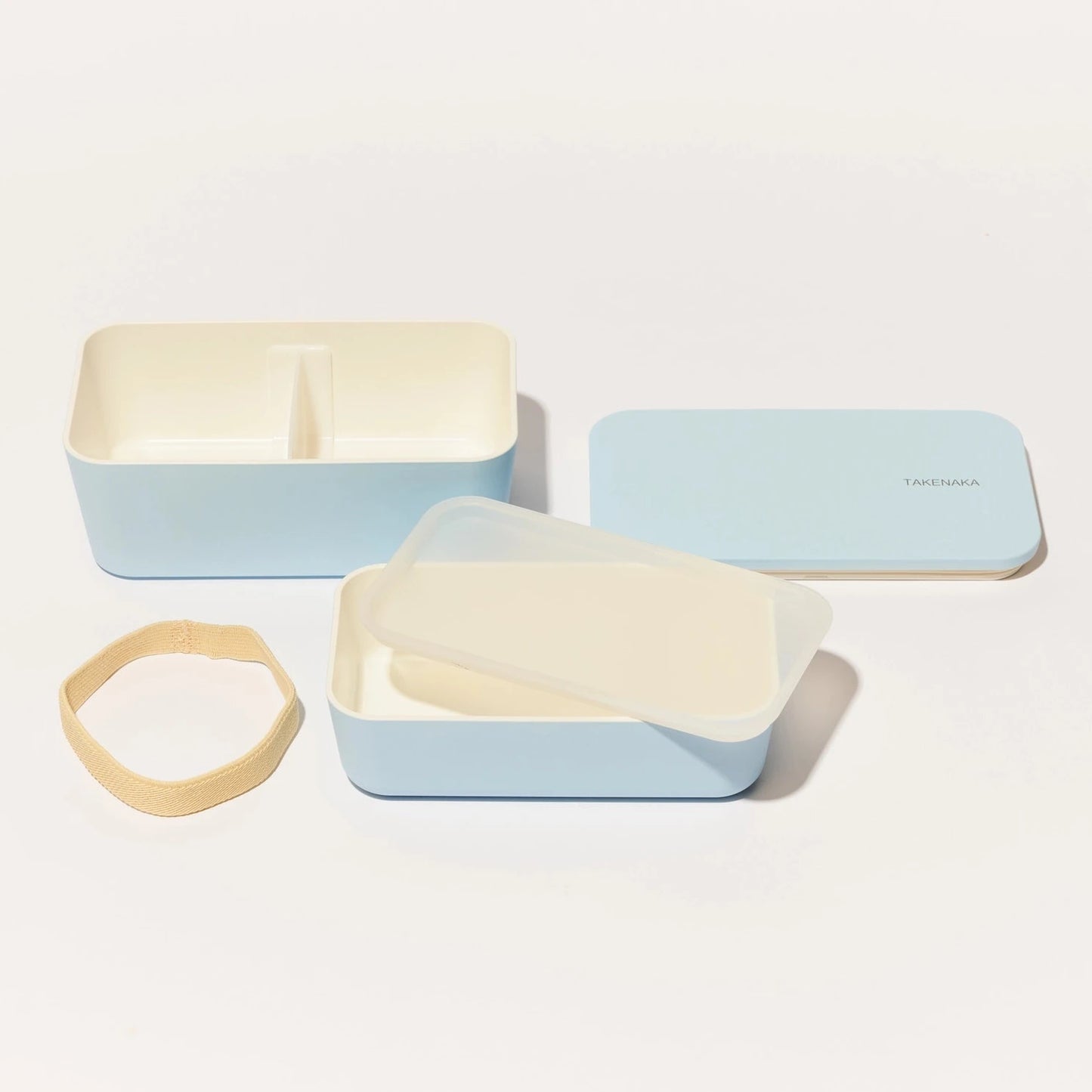 Two light blue containers with beige lids on a white background