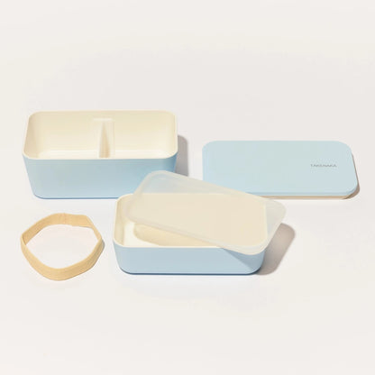 Two light blue containers with beige lids on a white background